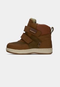 Zapatos altos de cuero marrón y gamuza con dos correas de Velcro, detalles texturizados y suela de goma beige. Logo de la marca visible en el costado.