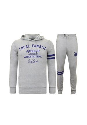 Lichtgrijze hoodie en joggingbroek set met blauwe tekst en strepen, met "Local Fanatic" branding en atletische stijl details.