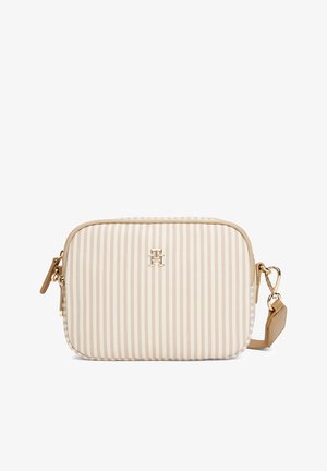 Beige striped crossbody bag with a gold zipper, featuring a logo emblem on the front and a detachable strap for versatile carrying.