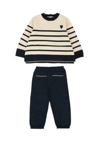 Maglione a righe crema e blu navy con dettaglio a cuore, abbinato a pantaloni blu navy a tinta unita con tasche posteriori decorative e polsini a costine.