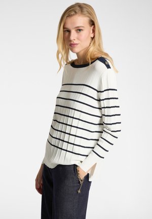Rippiger weißer Pullover mit navyfarbenen horizontalen Streifen, rundem Ausschnitt und Knopfdetails an den Schultern. Seitenschlitze am Saum.