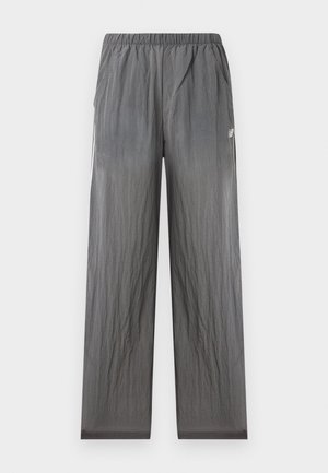 Pantalon de sport gris léger avec taille élastique, poches latérales et petit logo blanc New Balance sur la hanche droite.