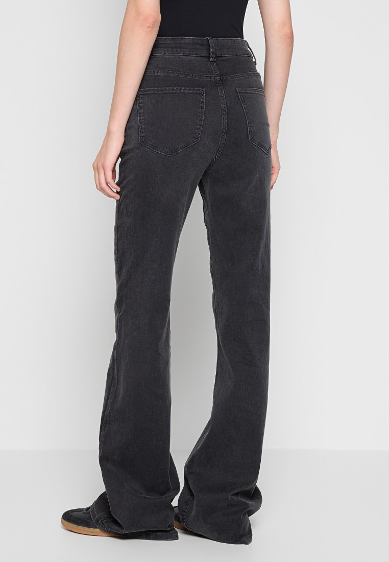 Zwarte wijde jeans met een hoge taille. Gemaakt van een katoenmix, met twee achterzakken en een gladde textuur.