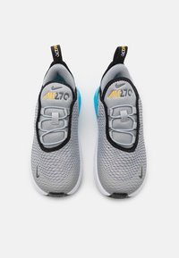 Grå nät-sneakers med en blå häl, svarta accentfärger, elastiska snören och "Air 270"-logotyp i gult. Rundad tå och platt sula.