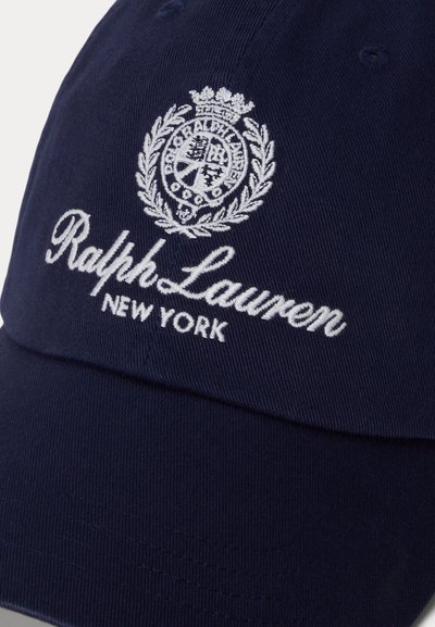 Casquette bleu marine avec texte Ralph Lauren New York brodé en blanc et un blason circulaire présentant une couronne et une couronne de laurier.