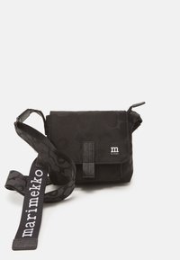 Black crossbody bag made of fabric, featuring a textured pattern, flap closure, and a printed strap with "marimekko" logo.