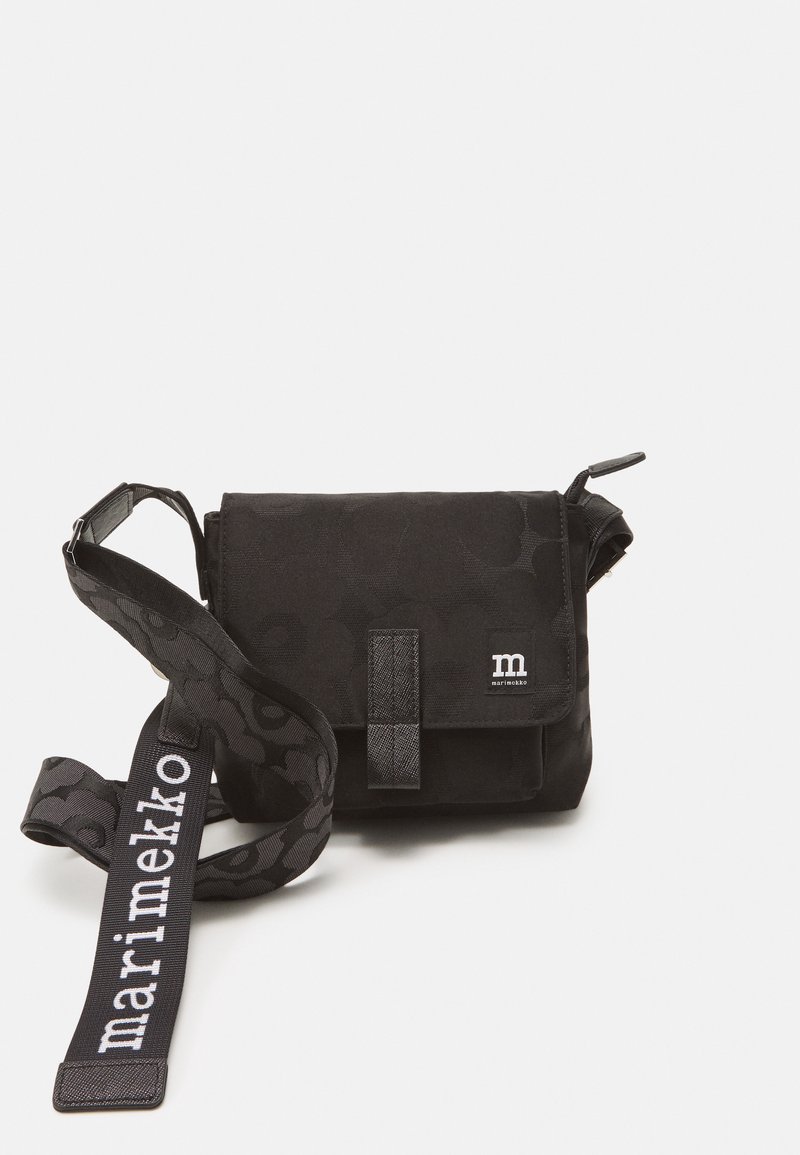 Black crossbody bag made of fabric, featuring a textured pattern, flap closure, and a printed strap with "marimekko" logo.