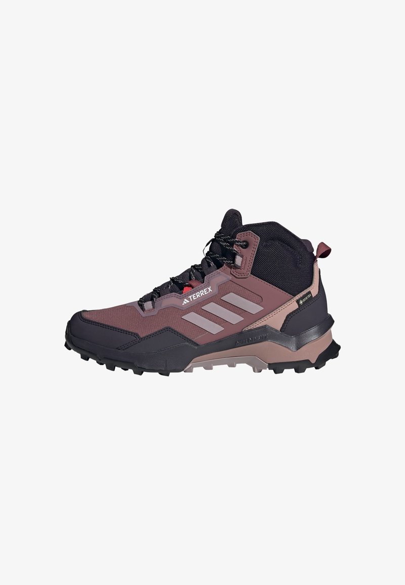 Turistická obuv s bordo a černým svrškem, syntetickými materiály, vysokou podporou kotníku, texturovanou podrážkou a výraznými bílými pruhy Adidas.
