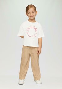 Weißes Kurzarm-T-Shirt mit "Awesome Love" in Pink, kombiniert mit beigen, gerippten, weiten Hosen. Das Outfit wird durch weiße Sneakers abgerundet.