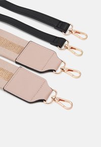 Regulowane paski do torby w czarnym i beżowym materiale z metalowymi klamrami w złotym odcieniu; cechują się plecionym wzorem i teksturowaną tkaniną.