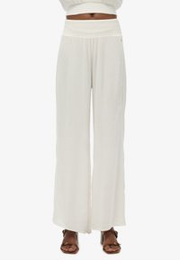 Pantalones blancos de pierna ancha hechos de tejido ligero con una cinturilla fruncida. Presentan un detalle lateral con pequeños acentos para añadir textura.