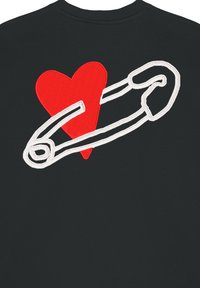 Maglietta nera con motivo a cuore rosso e spilla di sicurezza ricamata in bianco. Tessuto testurizzato con scollo rotondo e maniche corte.