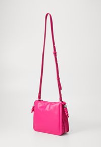 Ροζ συνθετική τσάντα χιαστί με επίπεδο σχέδιο, ρυθμιζόμενο λουρί και πλεχτές λεπτομέρειες στις πλευρές. Λείος υφασμάτινος υφιστάμενος και ασημί αξεσουάρ.