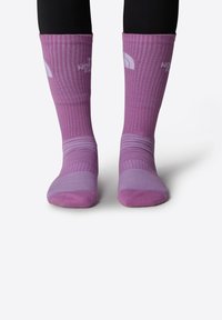 Medias hasta la rodilla de color púrpura con textura acanalada, con acentos de púrpura más claro en la puntera y el talón, y detalles del logotipo en blanco cerca de la parte superior.