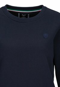 Marineblauwe sweatshirt met een ronde halslijn, voorzien van een klein geborduurd schildlogo op de borst en een gestreepte afwerking aan de binnenkant van de kraag.