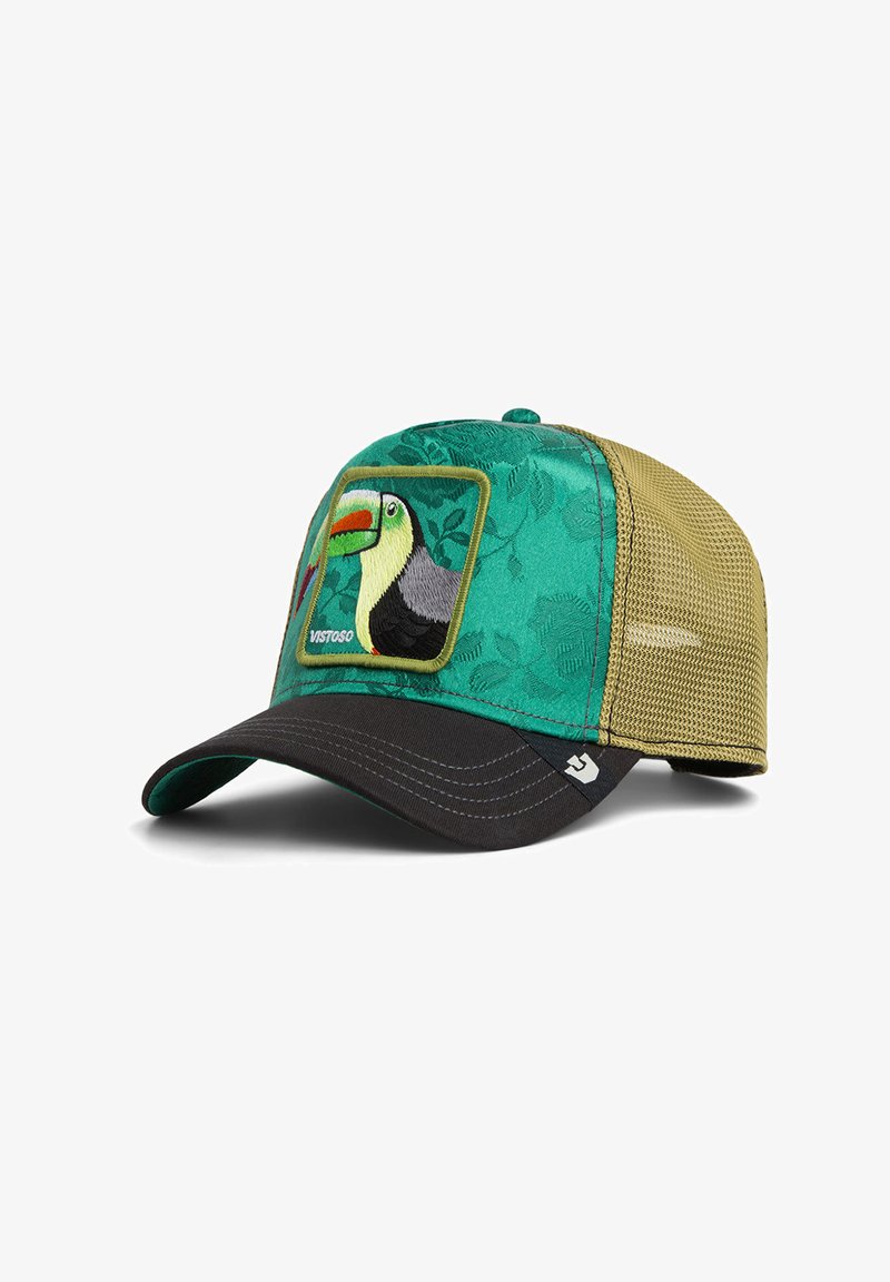Gorra de camionero verde y negra con malla beige en la parte trasera, con parche bordado de tucán y un sutil patrón de hojas en el panel frontal.