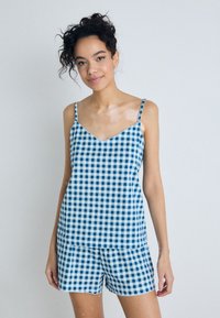 Blue and white gingham-patterned pajama set made of lightweight fabric, featuring a v-neck top with thin straps and matching shorts.