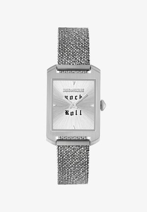 Hopeanvärinen suorakaiteen muotoinen rannekello verkkorannekkeella, auringonsäteiden kuvio dialissa, musta "rock roll" -teksti ja "Zadig & Voltaire" -merkki klo 12:n kohdalla.