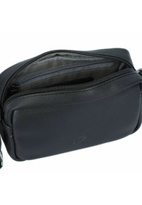 Schwarze Leder-Reißverschlusstasche mit einer strukturierten Oberfläche, ausgestattet mit einer Innentasche zur Organisation und einem einfachen, kompakten Design.