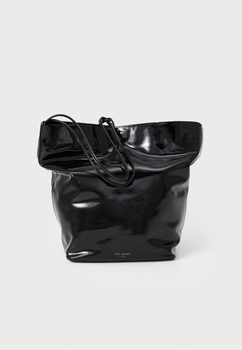 Bolso tote negro brillante con una textura suave y arrugada. Cuenta con dos asas alargadas y un logo impreso en la parte inferior. Diseño espacioso.