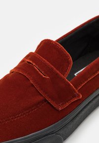 Rote Samt-Loafer mit strukturierter Oberfläche, einer über dem Spann abgesteppten Lasche und einer schwarzen Gummisohle.