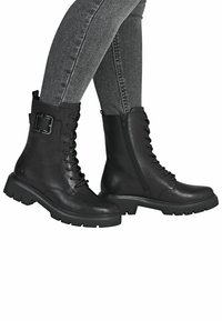 Bottines en cuir noir avec lacets, fermeture éclair latérale et accent en boucle en métal. Semelle en caoutchouc épaisse et texture lisse. Convient à diverses occasions.