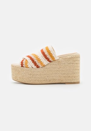 Sandalia de plataforma con cuña y suela de yute trenzado, superior de ganchillo a rayas multicolores en tonos blanco, naranja y amarillo.