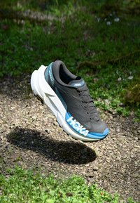 Buty do biegania HOKA w kolorze czarnym z niebieskimi akcentami i białą podeszwą, charakteryzujące się amortyzującą konstrukcją i teksturowaną cholewką dla wsparcia.