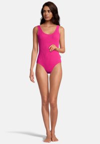 Maillot de bain une pièce fuchsia avec un design texturé côtelé. Il présente une encolure dégagée et des bretelles larges, offrant une silhouette ajustée.