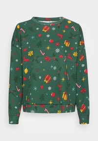 Pull de Noël vert avec rennes rouges, cannes en sucre d’orge, cœurs, cadeaux, flocons de neige, houx, étoiles et motif d’ornements.