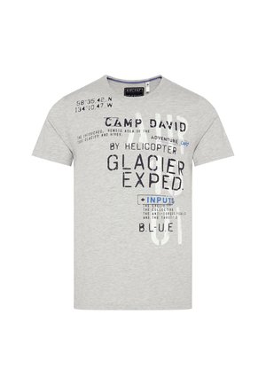 Szara bawełniana koszulka z okrągłym dekoltem i krótkimi rękawami, z mieszanymi nadrukami typograficznymi w niebieskim i czarnym kolorze. Tekst zawiera współrzędne oraz nazwę marki.