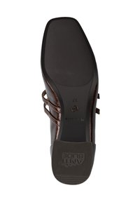Chaussure en cuir brun avec un dessus texturé, dotée de deux fines lanières et d'une semelle en caoutchouc lisse. Logo en relief au niveau du talon. Taille 37.