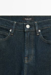 Mörkblå denimjeans med rak passform, med kopparstickning, en knapp framtill och en "Massimo Dutti"-etikett i midjan.