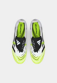 Par nogometnih kopačka Adidas Predator u bijeloj, crnoj i neonskoj žutoj boji s crnim flapovima jezika na kojima se prikazuje bijeli Adidas logotip, viđeno iznad.