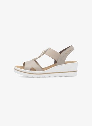 Beige Wedgesandalen mit offener Zehe, elastischen Riemen und dekorativen Beschlägen. Weiße Sohle mit korkähnlichem Akzent. Glatte Textur.