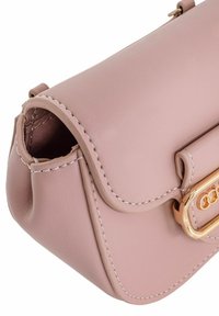 Różowa torebka skórzana z klapą, złotymi akcesoriami i białym przeszyciem. Zaokrąglone krawędzie oraz elegancki, kompaktowy design.