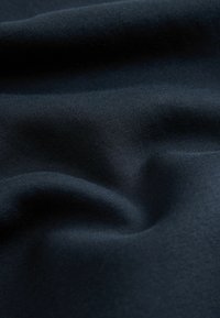 Tejido de un oscuro tono azul marino con una textura suave, que presenta pliegues sutiles y una superficie uniforme. Adecuado para diversas aplicaciones textiles.