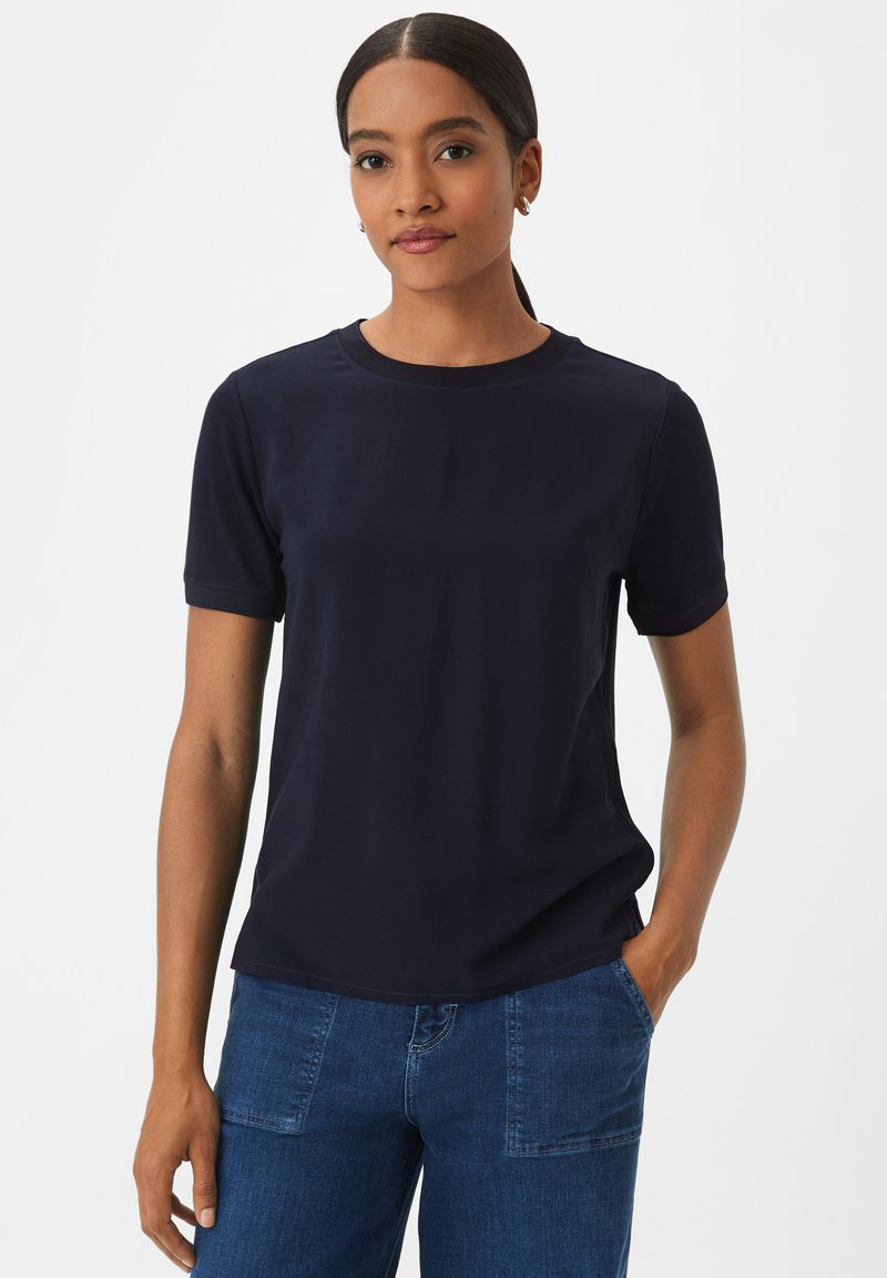 Marineblaue kurzärmlige T-Shirt aus weichem Material, mit Rundhalsausschnitt und lockerer Passform, kombiniert mit Jeans.