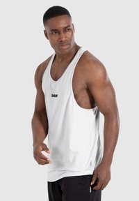 Hellgraues Sporttanktop aus glattem Stoff, mit einem runden Halsausschnitt, weiten Armausschnitten und kleinem Logo auf der Vorderseite.