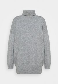 Mjuk, ljusgrå polotröja med långa ärmar och avslappnad passform. Tillverkad av stickat tyg med ribbade detaljer vid fållen.