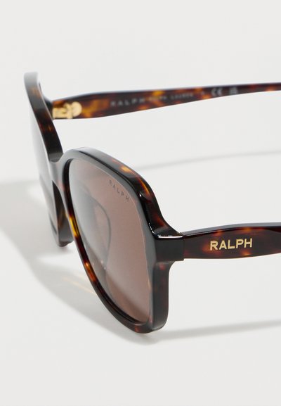 Τετράγωνα γυαλιά ηλίου σε σχέδιο χελώνας με καφέ φακούς, λογότυπο "RALPH" σε χρυσό στο κρυφό μέρος και διακριτική σήμανση στη γωνία του φακού.