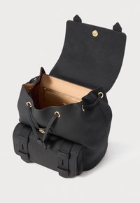 Μαύρη δερμάτινη τσάντα σε σχήμα κουβά με κορδόνι, μπροστινή τσέπη με αγκράφα, και ανοιχτό καπάκι που δείχνει εσωτερικό κωδικοποιημένο διαμέρισμα σε μπεζ χρώμα και χρυσές λεπτομέρειες.