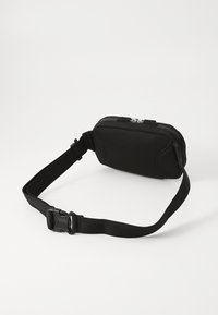 Borsa rettangolare nera in tessuto testurizzato, con chiusura a zip e tracolla regolabile. La componentistica include una fibbia in plastica.