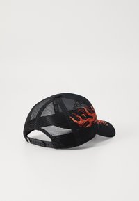 Crna kapica s mrežastim stražnjim dijelom, s crvenim vezom u obliku plamena sprijeda. Struktuirani dizajn s zakrivljenim vizorom i podesivim remenom.