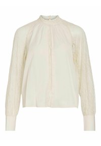Blouse crème à manches longues avec manches en dentelle, col montant à volants, fermeture boutonnée au dos et coupe ample.