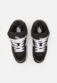 Adidași negri din suede cu dantelii și accente albe. Prezintă un guler căptușit, design joasă și un logo Vans proeminent pe limbă.