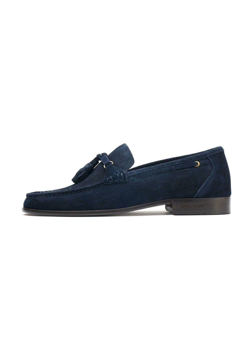 Navy blue suede loafers featuring a tassel accent, rounded toe, and a low wooden heel, with stitched detailing along the edges.