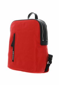 Sac à dos en nylon rouge avec des accents noirs, équipé de deux fermetures éclair latérales, d'une poche zippée à l'avant et d'une poignée supérieure pour le transport. Forme compacte et carrée.