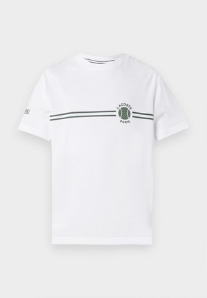White cotton t-shirt with short sleeves, featuring a green striped design and a circular Lacoste logo on the chest. Smooth texture.