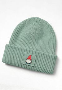 Knitted mint green beanie with a ribbed texture, featuring a folded cuff and a square patch displaying a gnome illustration.